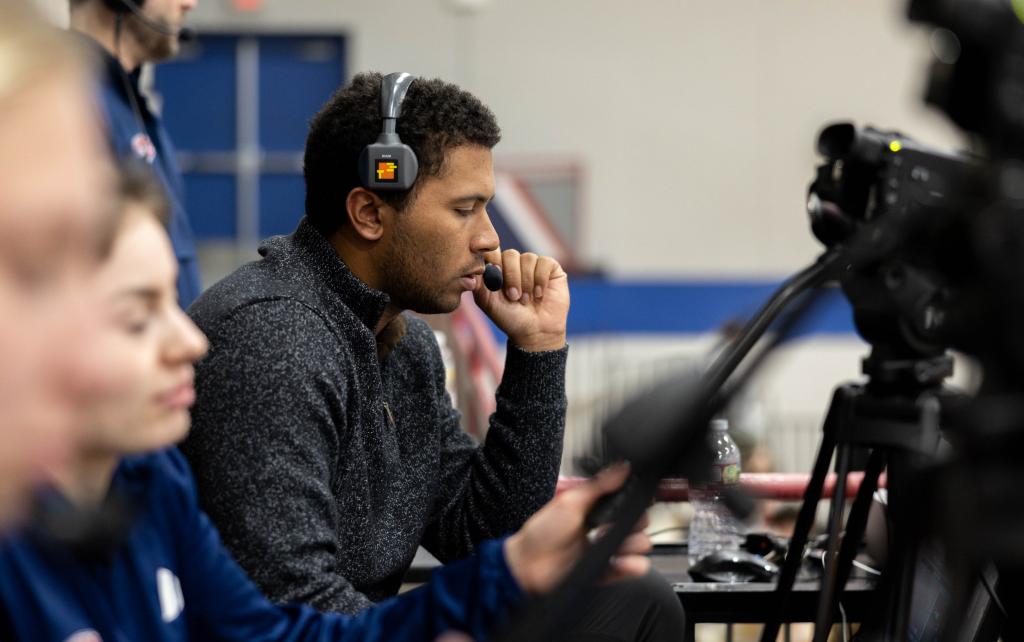 Student operating a sound board at a sports game